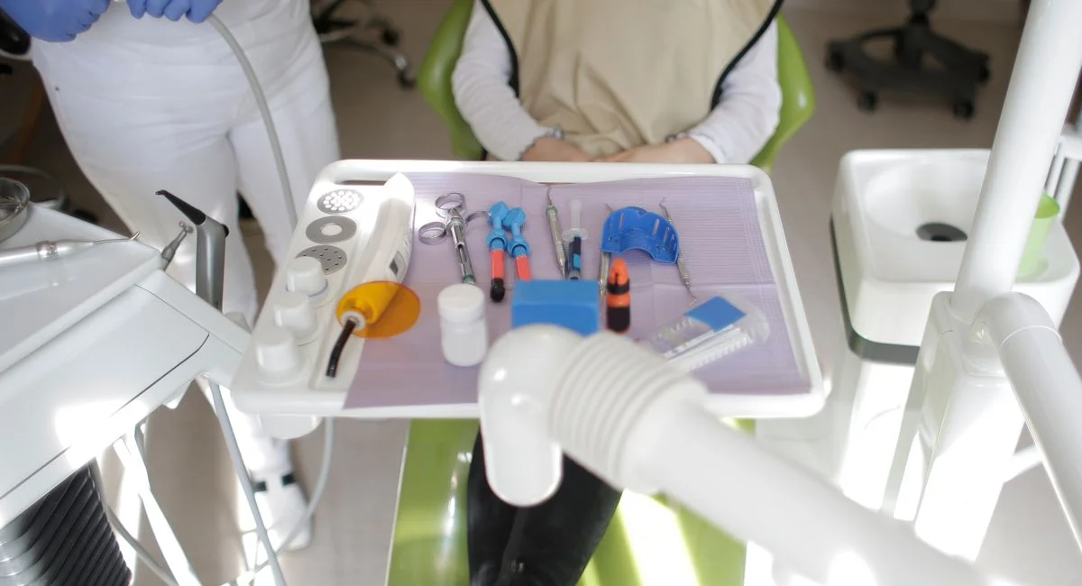 A dental office setup with tools and a patient ready for examination. Healthcare environment in focus.
