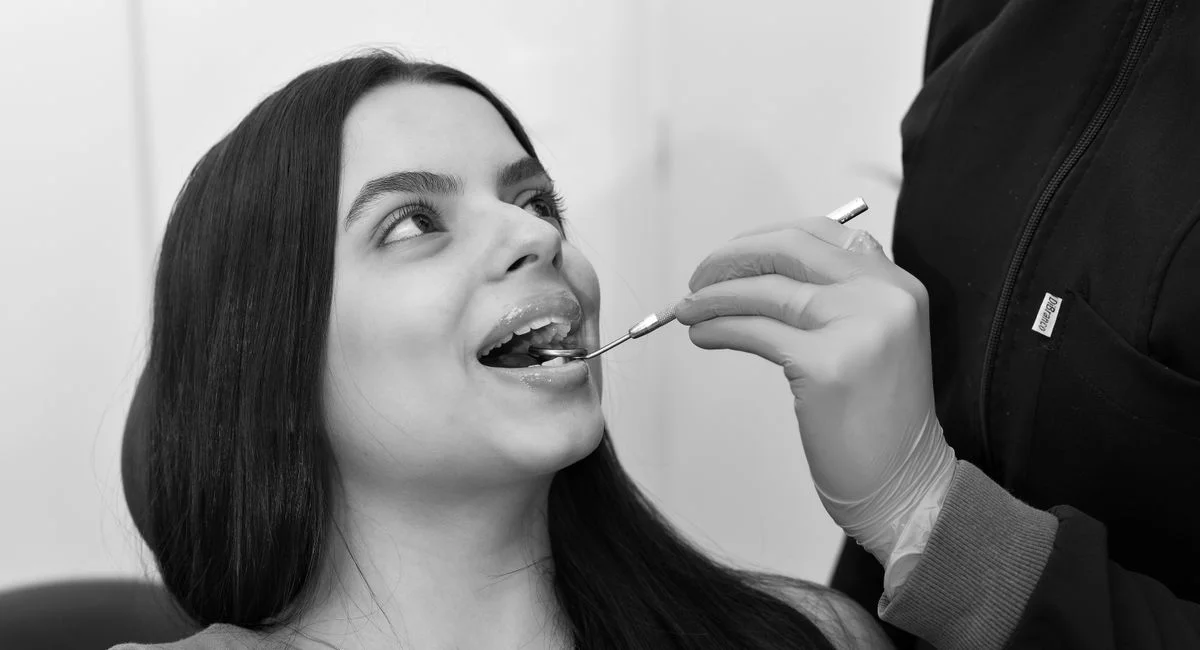 Black and white photo of a woman receiving a dental checkup in Belo Horizonte, Brazil.
