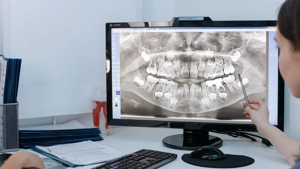 Une dentiste examine une radiographie panoramique dentaire sur un écran