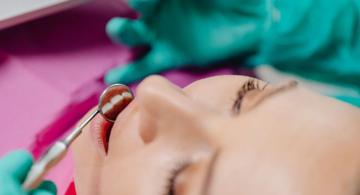 Patient undergoing a dental examination, focusing on tools and technique.