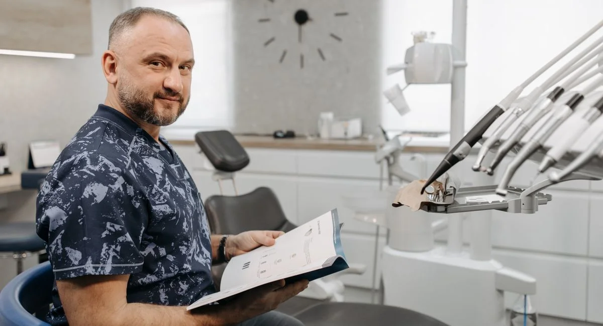 A dentist reviews patient records in a modern dental clinic setting.