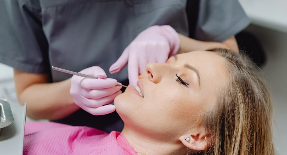 A female patient receives a dental examination by a dentist in a clinic.