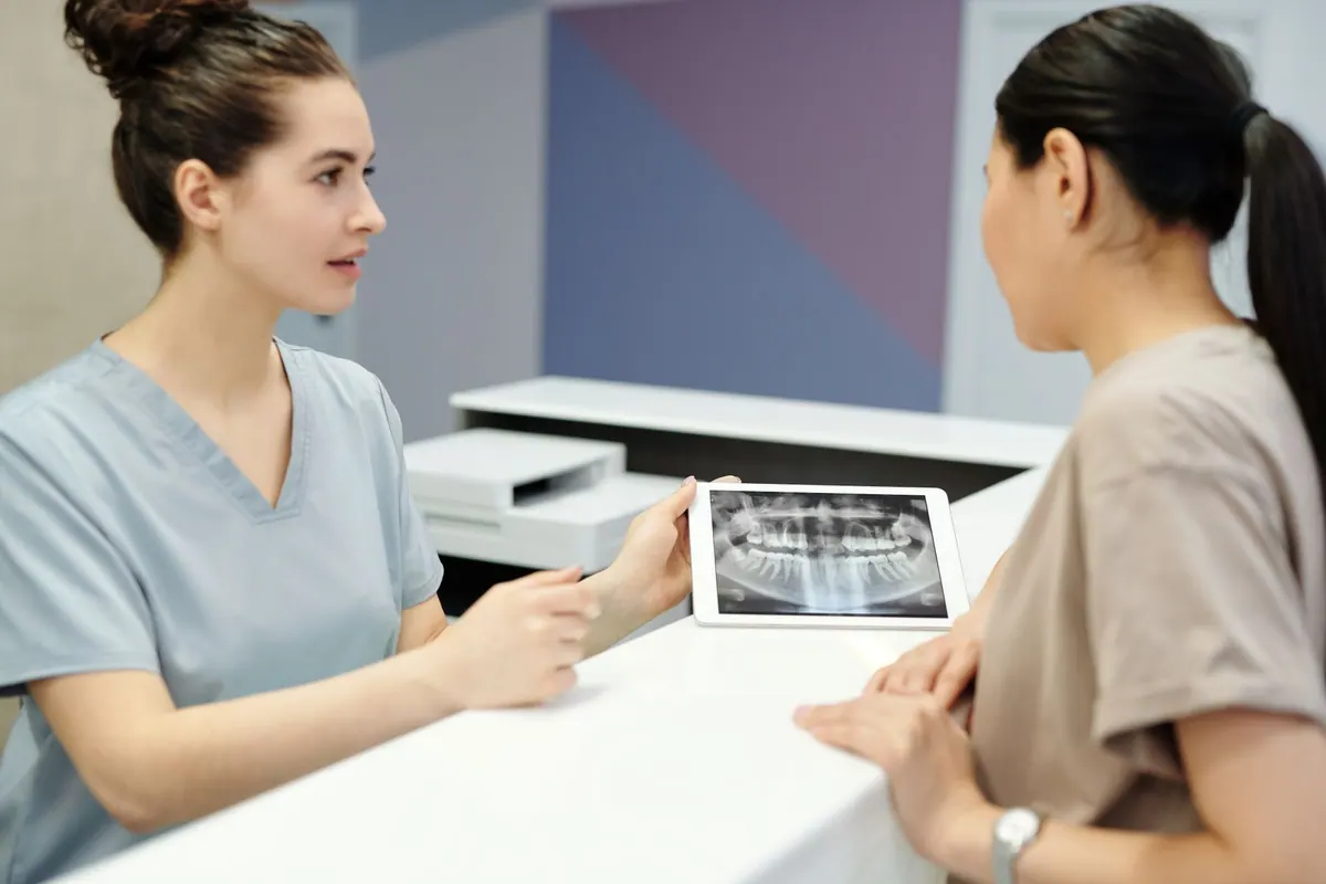Dentiste expliquant une radiographie dentaire à une patiente